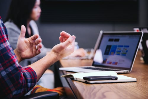 Man gesturing in front of computer